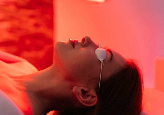 Vertical,Shot,Of,Young,Woman,Having,Red,Led,Light,Facial